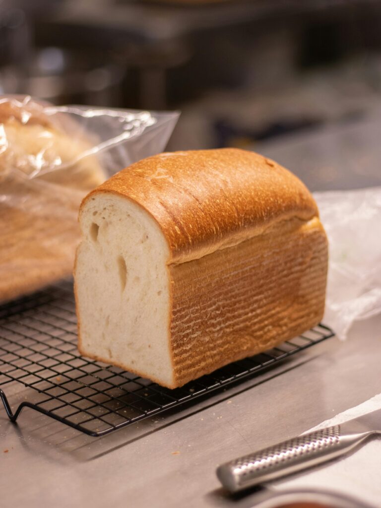 A warm loaf of bread cooling on a rack in a bakery setting.